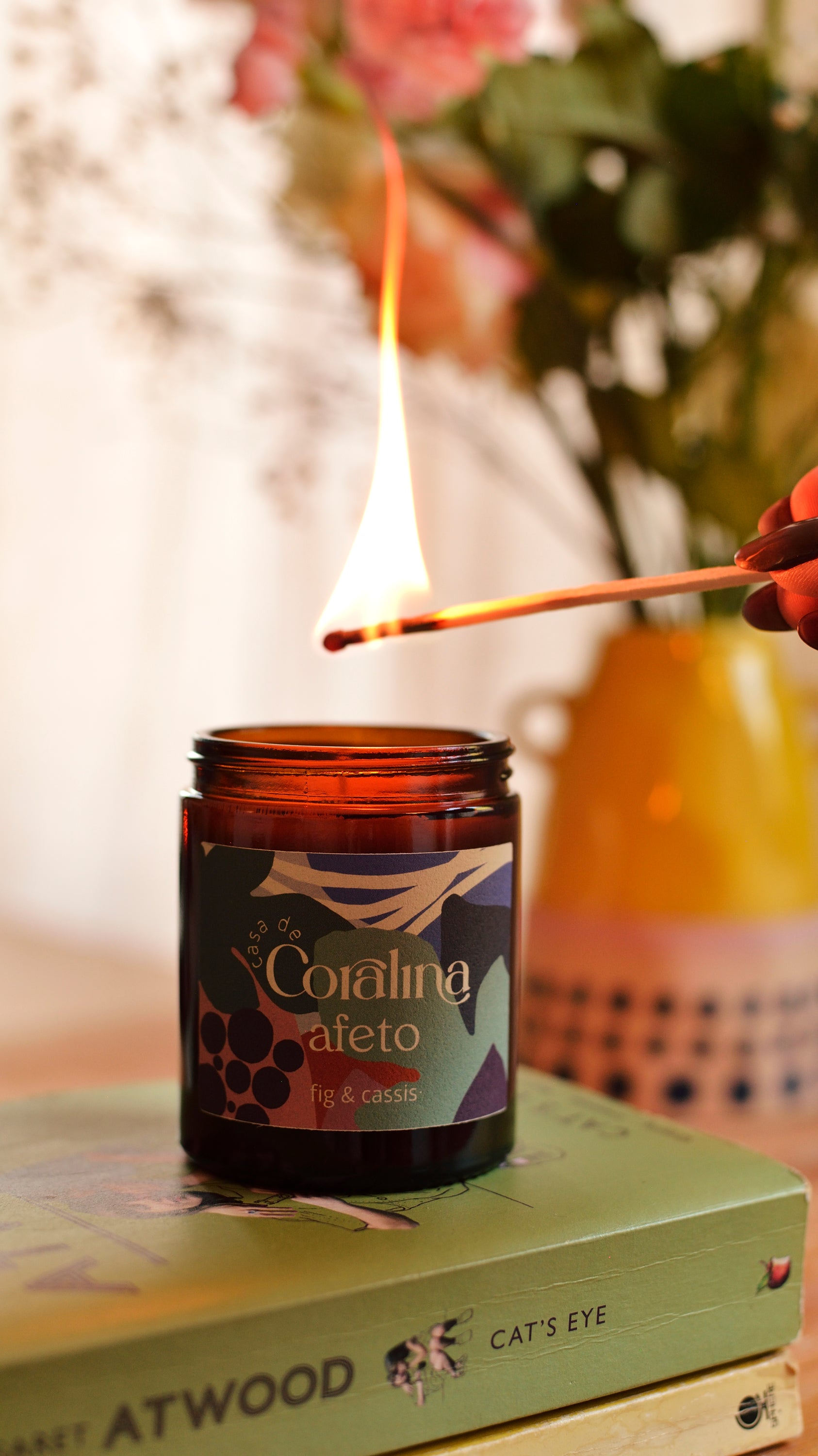 Candle being lit with a match, placed on a book with a blurred background